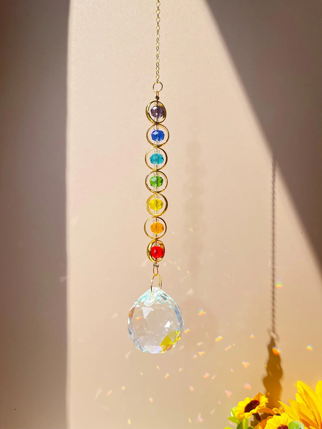 Suncatcher multicolor colgado al sol con prisma y reflejos arcoíris